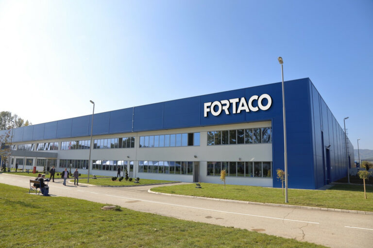 A blue building with people walking in front of it.